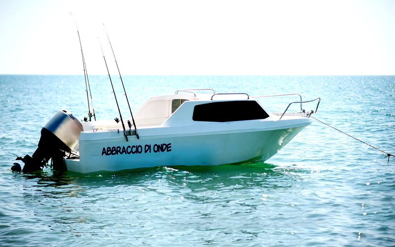 Nome barca Abbraccio di Onde applicato su barca bianca in mare